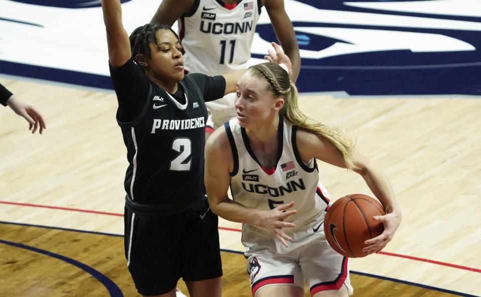 Connecticut guard Paige Bueckers (5) drives the ball against Providence guard Chanell Williams (2) during the first half of an NCAA college basketball game at Harry A. Gampel Pavilion, Saturday, Jan. 9, 2021, in Storrs, Conn. (David Butler II/Pool Photo via AP)
