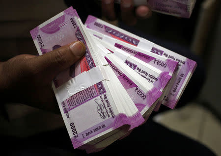 FILE PHOTO: A cashier displays the new 2000 Indian rupee banknotes inside a bank in Jammu, November 15, 2016. REUTERS/Mukesh Gupta/File photo