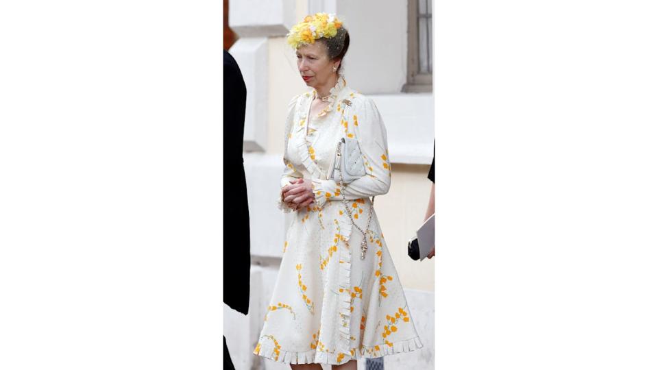 Princess Anne in a white ruffled dress and yellow headpiece