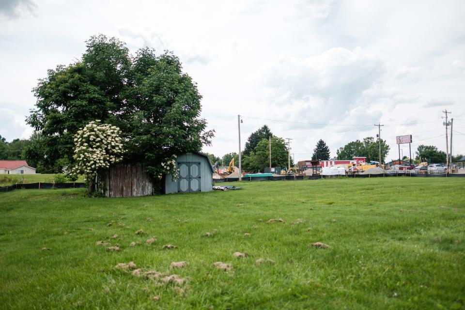 A temporary fence line can be seen marking the edge of the Gardner Street Garage property in Uhrichsville, owned by John Fockler. Beyond the fence is an ongoing construction project, which he says causes issues with access to his property as well as increased flooding. Fockler noted that when flooding is bad, he cannot access the sheds, among other issues.