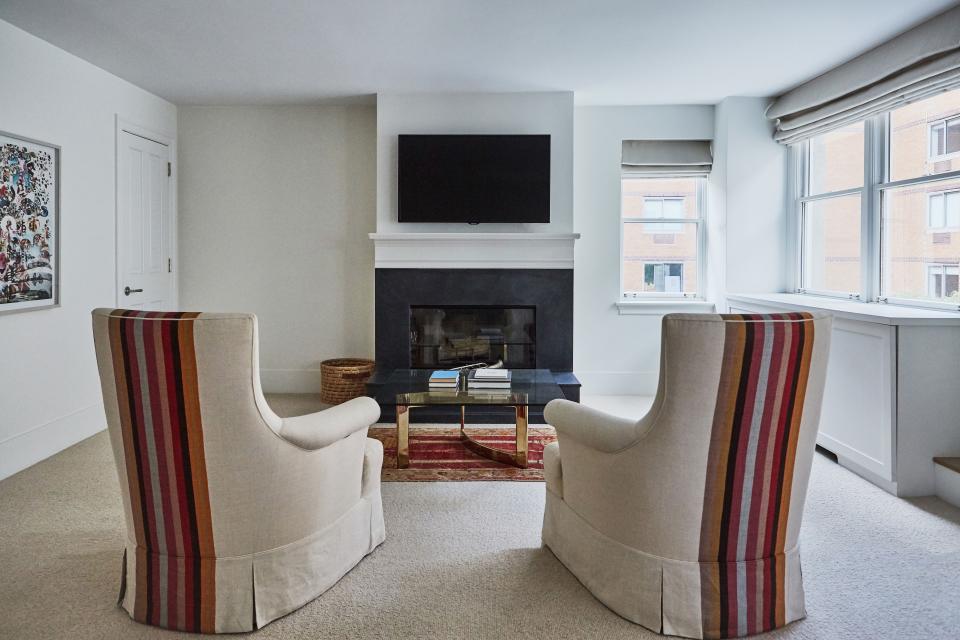 Though the upholstered chairs may be the highlight of this sitting area, other details are not to be missed: The coffee table is a mid-century find and the rug was purchased through Bonhams. The fireplace was redone with black slate.