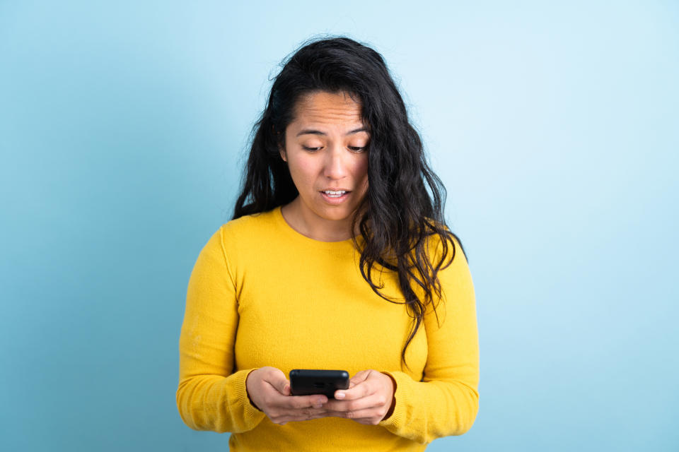 a woman looking at her phone in shock