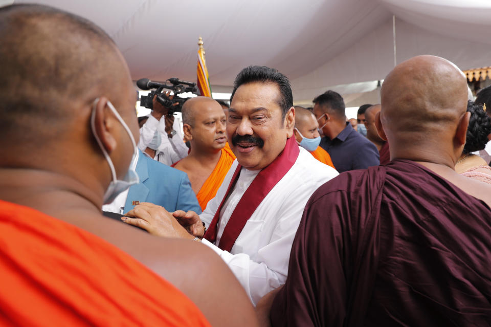 Sri Lanka’s former President Mahinda Rajapaksa, center, speaks with well wishing Buddhist monks after he was sworn in as the prime minister at Kelaniya Royal Buddhist temple in Colombo, Sri Lanka, Sunday, Aug. 9, 2020. (AP Photo/Eranga Jayawardena)