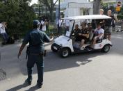 A policeman signals to a buggy carrying Red Bull Formula One driver Sebastian Vettel of Germany (waving, at back) ahead of the third practice session of the Singapore F1 Grand Prix at the Marina Bay street circuit in Singapore September 21, 2013. REUTERS/Natashia Lee (SINGAPORE - Tags: SPORT MOTORSPORT F1)