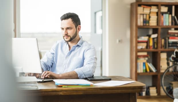 Young man working at computer at home