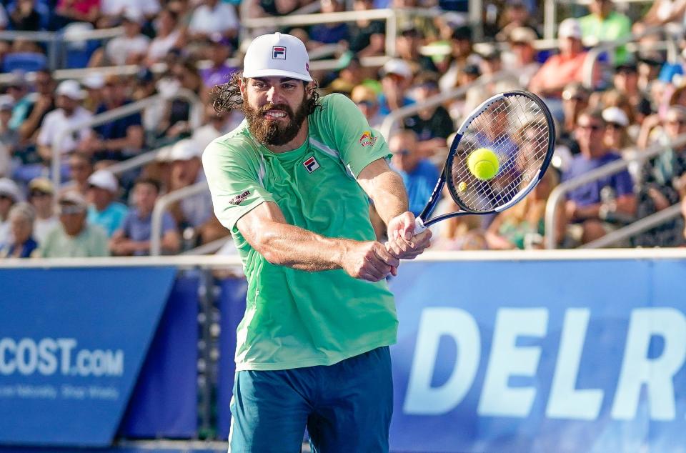 Reilly Opelka returns a volley during his 7-6 (6-1), 7-6 (6-4) loss to Cameron Norrie in the finals of the Delray Beach Open at the Delray Beach Stadium and Tennis Center on Sunday, Feb. 20, 2022.