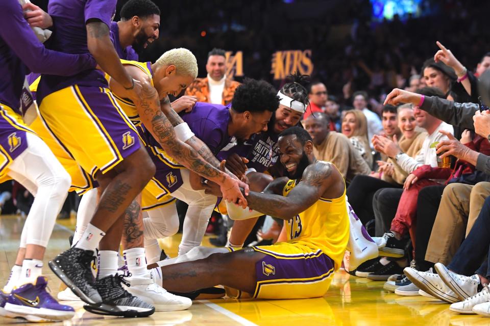 Los Angeles Lakers forward LeBron James I swarmed by teammates after making several 3-point shots in a row during the second half of the team's NBA basketball game against the San Antonio Spurs on Tuesday, Feb. 4, 2020, in Los Angeles. (AP Photo/Mark J. Terrill)