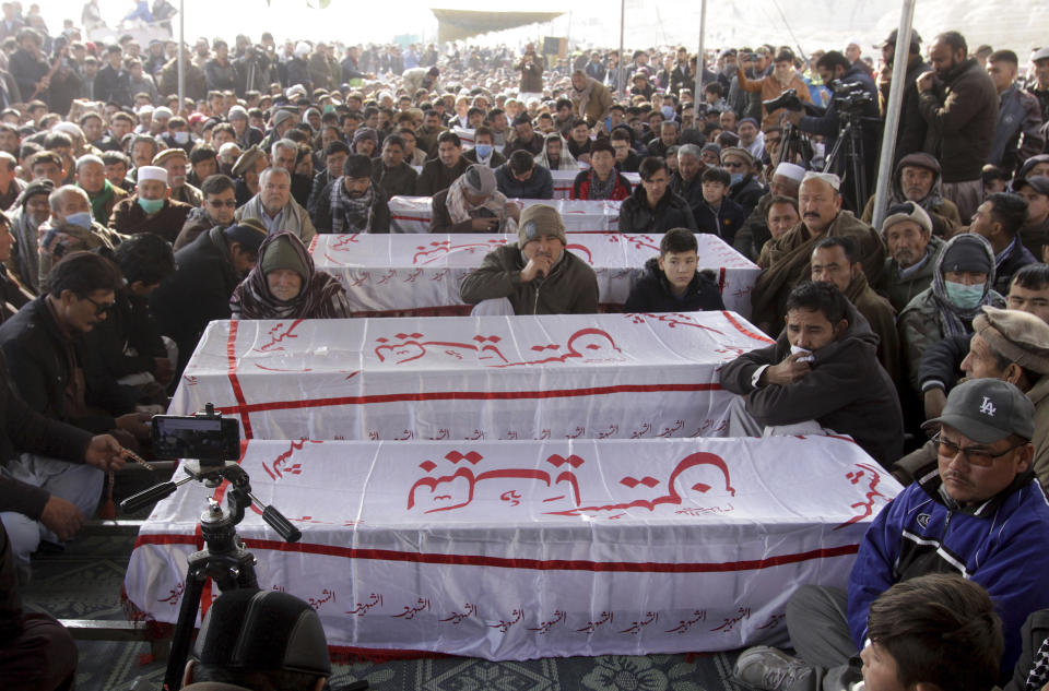 People from the Shiite Hazara community gather around the caskets of coal mine workers who were killed by unknown gunmen near the Machh coal field, during a sit-in protest, in Quetta, Pakistan, Monday, Jan. 4, 2021. Gunmen opened fire on a group of minority Shiite Hazara coal miners after abducting them, killing 11 in southwestern Baluchistan province early Sunday, a Pakistani official said. (AP Photo/Arshad Butt)