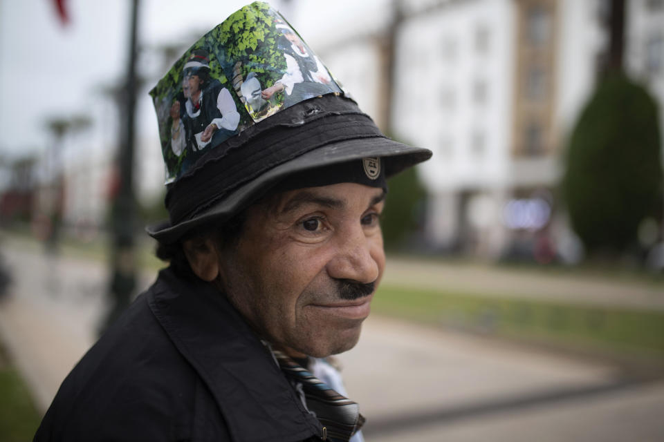 Belhussein Abdelsalam, a Charlie Chaplin impersonator pauses while waiting for customers in an avenue in Rabat, Morocco, Wednesday, Dec. 16, 2020. When 58-year-old Moroccan Belhussein Abdelsalam was arrested and lost his job three decades ago, he saw Charlie Chaplin on television and in that moment decided upon a new career: impersonating the British actor and silent movie maker remembered for his Little Tramp character. (AP Photo/Mosa'ab Elshamy)