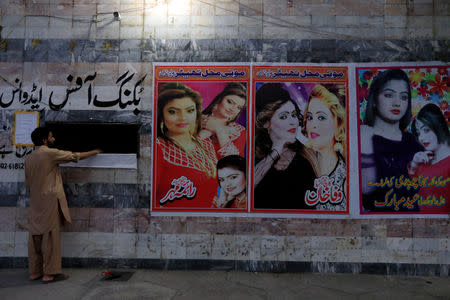 A man stands at the ticket counter with film posters at a cinema in Rawalpindi, Pakistan August 30, 2018. REUTERS/Faisal Mahmood