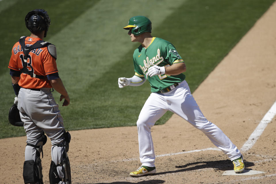 Oakland Athletics' Matt Chapman, right, tags home plate beside Houston Astros catcher Dustin Garneau (13) after hitting a home run in the eighth inning of a baseball game Saturday, Aug. 8, 2020, in Oakland, Calif. (AP Photo/Ben Margot)