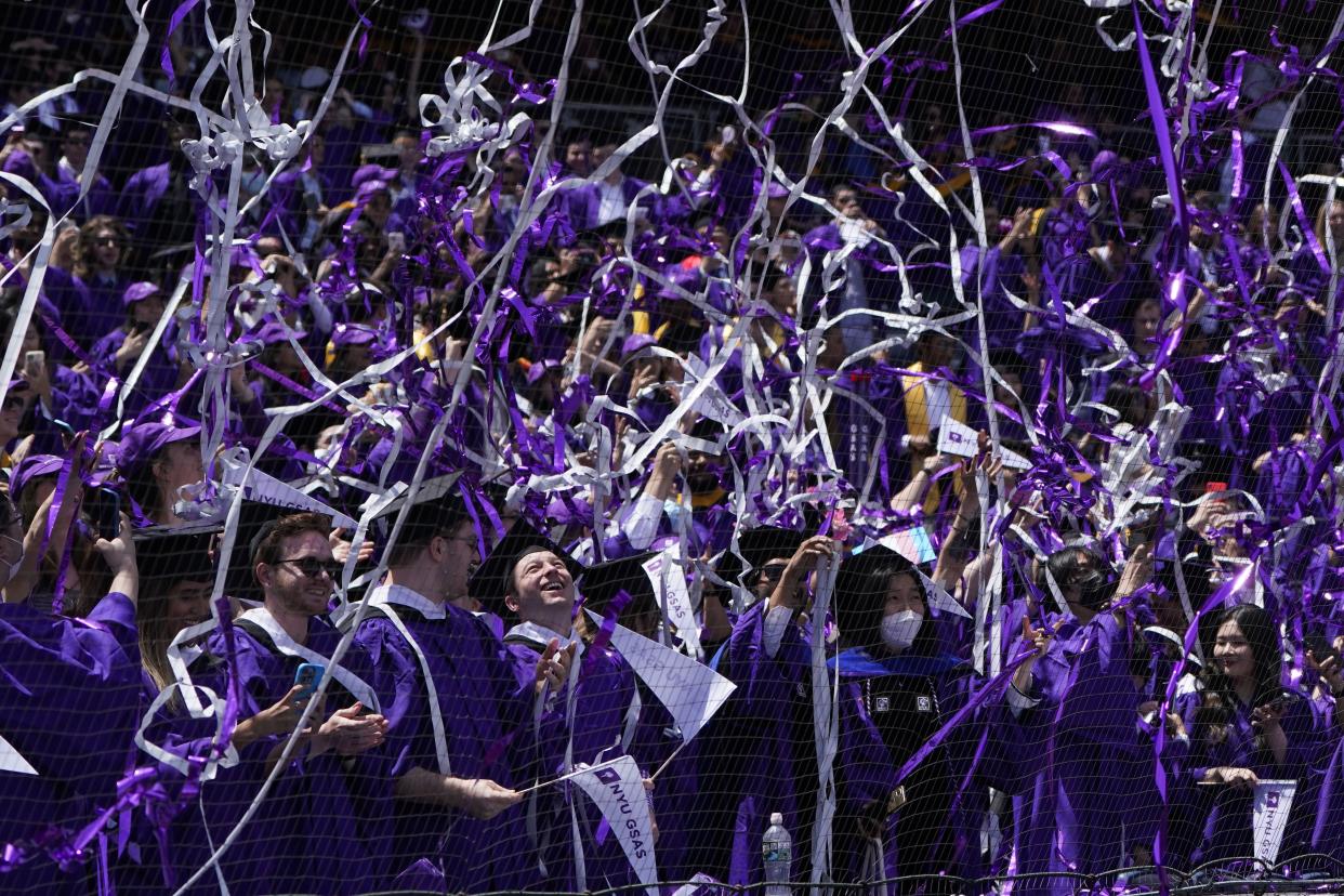 FILE - Confetti drops on graduates as they celebrate during a graduation ceremony for New York University at Yankee Stadium in New York, on May 18, 2022. 