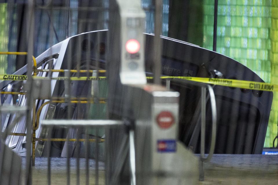 A derailed Chicago Transit Authority train car rests on an escalator at the O'Hare Airport station early Monday, March 24, 2014, in Chicago. More than 30 people were injured after the eight-car train plowed across a platform and scaled the escalator at the underground station. (AP Photo/Andrew A. Nelles)