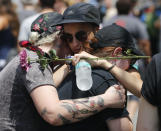 <p>Mourners embrace each other as they remember Heather Heyer who was killed during last year’s Unite the Right rally in Charlottesville, Va., Sunday, Aug. 12, 2018. On that day, white supremacists and counterprotesters clashed in the city streets before a car driven into a crowd struck and killed Heyer. (Photo: Steve Helber/AP) </p>