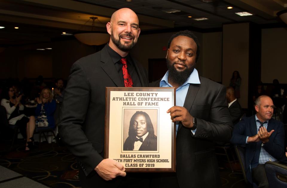 Dallas Crawford, a 2011 South Fort Myers High School graduate, is inducted into the Lee County Athletic Conference Hall of Fame on Thursday in Fort Myers. Crawford played football at South. South Fort Myers High School principal Ed Mathews, left, is among Crawford's supporters.