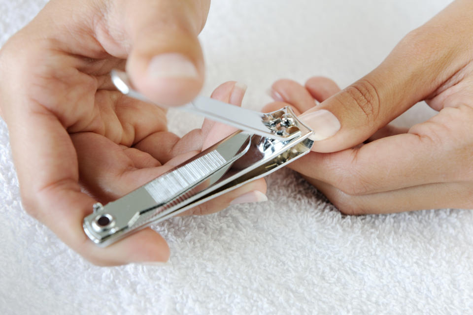 A woman clipping her fingernails