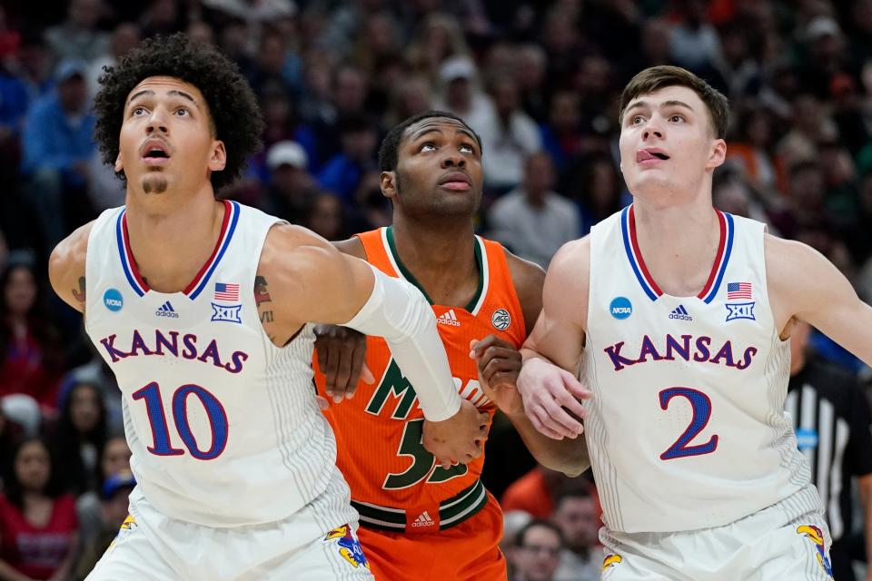 Kansas' Jalen Wilson and Christian Braun block out Miami's Wooga Poplar March 27 in Chicago. Wilson says he admires what Ochai Agbaji and Devonte' Graham accomplished during their years in Lawrence and hopes to follow in their footsteps.