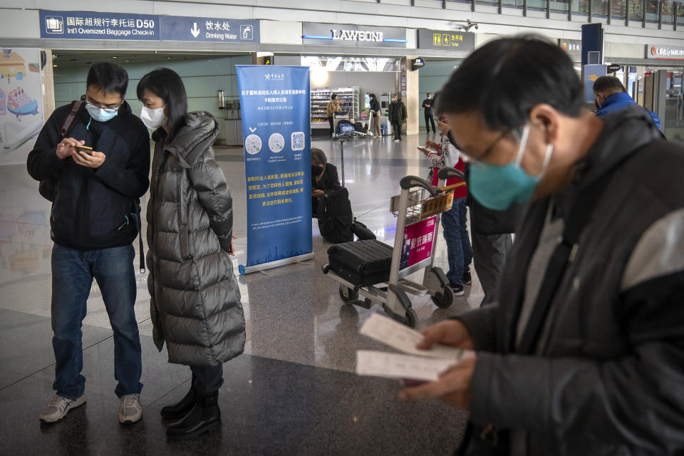 Travelers fill out an online electronic customs health declaration form before boarding an international flight at Beijing Capital International Airport in Beijing, on Jan. 15, 2023. (AP Photo/Mark Schiefelbein)