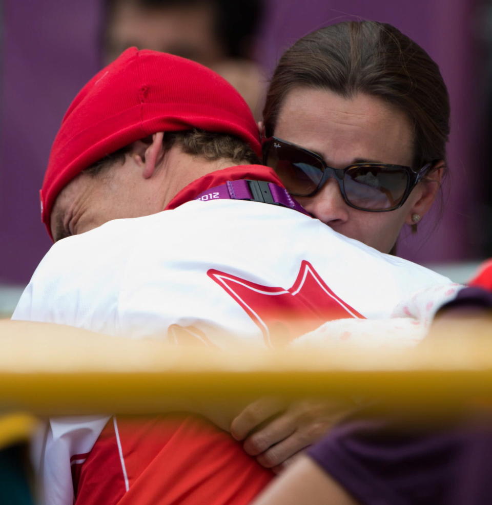 Canada's Simon Whitfield is hugged by his wife Jennie after crashing and retiring from the men's triathlon. (THE CANADIAN PRESS/Sean Kilpatrick)