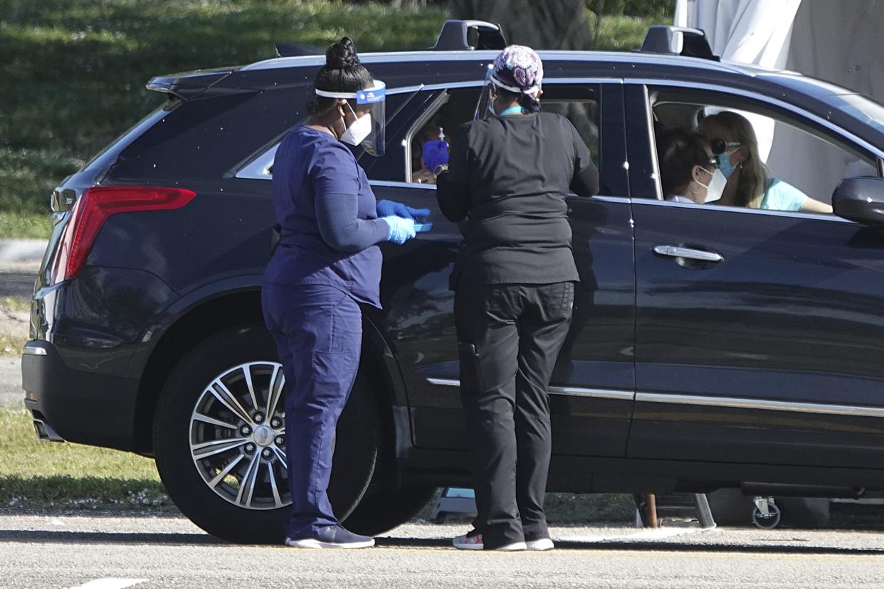 COVID-19 vaccines are administered to a senior in a car at Tradewinds Park in Coconut Creek, Fla. on Sunday, Jan. 3, 2021.