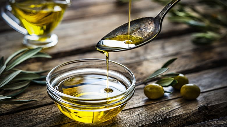 olive oil pouring into spoon