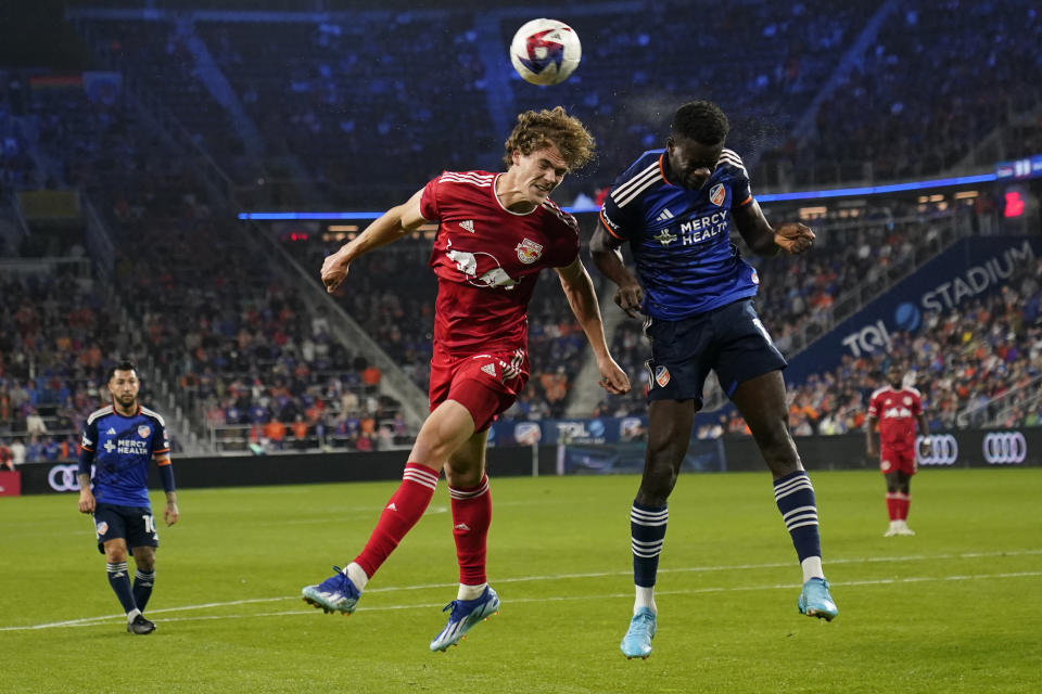 New York Red Bulls forward Tom Barlow (74) and FC Cincinnati forward Dominique Badji (14) go up to head the ball during the first half of an MLS playoff soccer match in Cincinnati, Sunday, Oct. 29, 2023. (AP Photo/Carolyn Kaster)