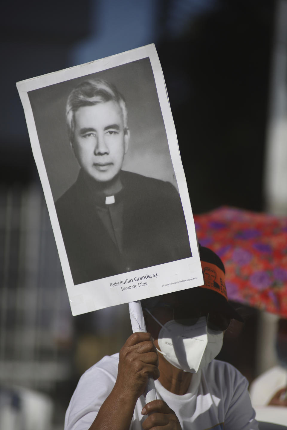 A woman holds a poster depicting the Rev. Rutilio Grande, during his beatification ceremony in San Salvador, El Salvador, Saturday, Jan. 22, 2022. The Roman Catholic Church beatified two priests, including Grande, and two lay people Saturday, all victims of right-wing death squads during El Salvador’s civil war. (AP Photo/Salvador Melendez)