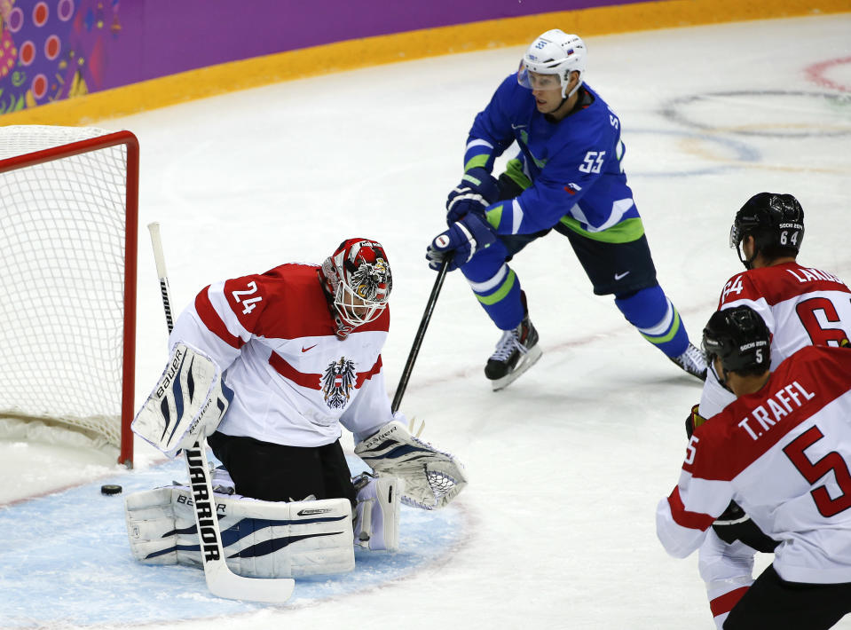 The puck, shot by Slovenia forward Anze Kopitar, slips past Austria goaltender Mathias Lange for a goal in the first period period of a men's ice hockey game at the 2014 Winter Olympics, Tuesday, Feb. 18, 2014, in Sochi, Russia. (AP Photo/Julio Cortez)