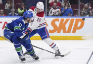 Montreal Canadiens' Alex Newhook, right, and Vancouver Canucks' Noah Juulsen vie for the puck during the second period of an NHL hockey game Thursday, March 21, 2024, in Vancouver, British Columbia. (Darryl Dyck/The Canadian Press via AP)