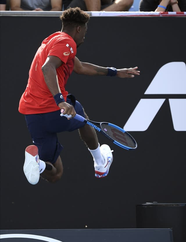 Gael Monfils leaps over an advertising board during his victory over Ivo Karlovic