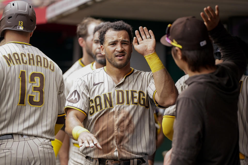 San Diego Padres' Trent Grisham, center, celebrates with teammates after scoring on a double hit by Fernando Tatis Jr. during the third inning of a baseball game against the Cincinnati Reds Saturday, July 1, 2023, in Cincinnati. (AP Photo/Jeff Dean)