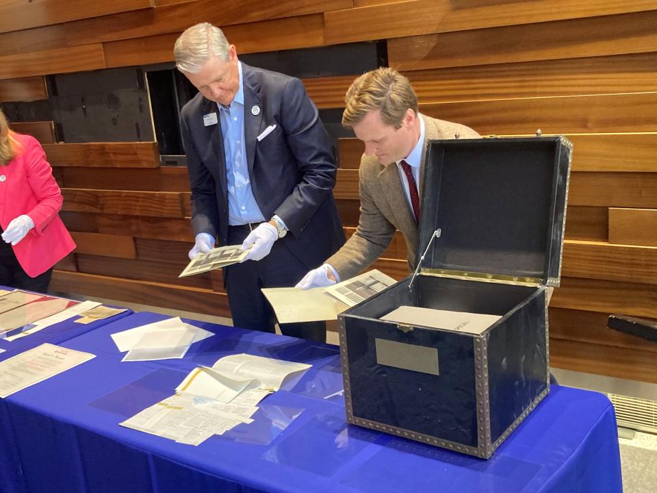 Curt Farmer, the chairman, president and CEO of Comerica Bank, and Jeremy Dimick, director of collections and curatorial at the Detroit Historical Society, sift through contents of the dusty black box.