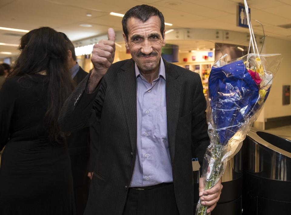 Ali Vayeghan gives a thumbs-up after arriving at the international terminal at Los Angeles International Airport in Los Angeles on Thursday, Feb. 2, 2017. Vayeghan, who had been turned away from the airport under President Donald Trump's executive order barring immigrants from seven Muslim-majority nations, returned Thursday to an emotional welcome from family members who greeted him with California-grown flowers and well-wishers who sang "This Land Is Your Land." (Ed Crisostomo/The Orange County Register via AP)