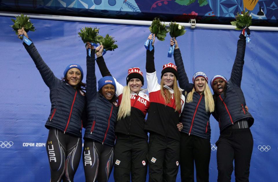 From left to right, silver medal winners from the United States Elana Meyers and Lauryn Williams, gold medal winners from Canada Kaillie Humphries and Heather Moyse, and bronze medal winners from the United States Jamie Greubel and Aja Evans pose during the flower ceremony during the women's bobsled competition at the 2014 Winter Olympics, Wednesday, Feb. 19, 2014, in Krasnaya Polyana, Russia. (AP Photo/Michael Sohn)