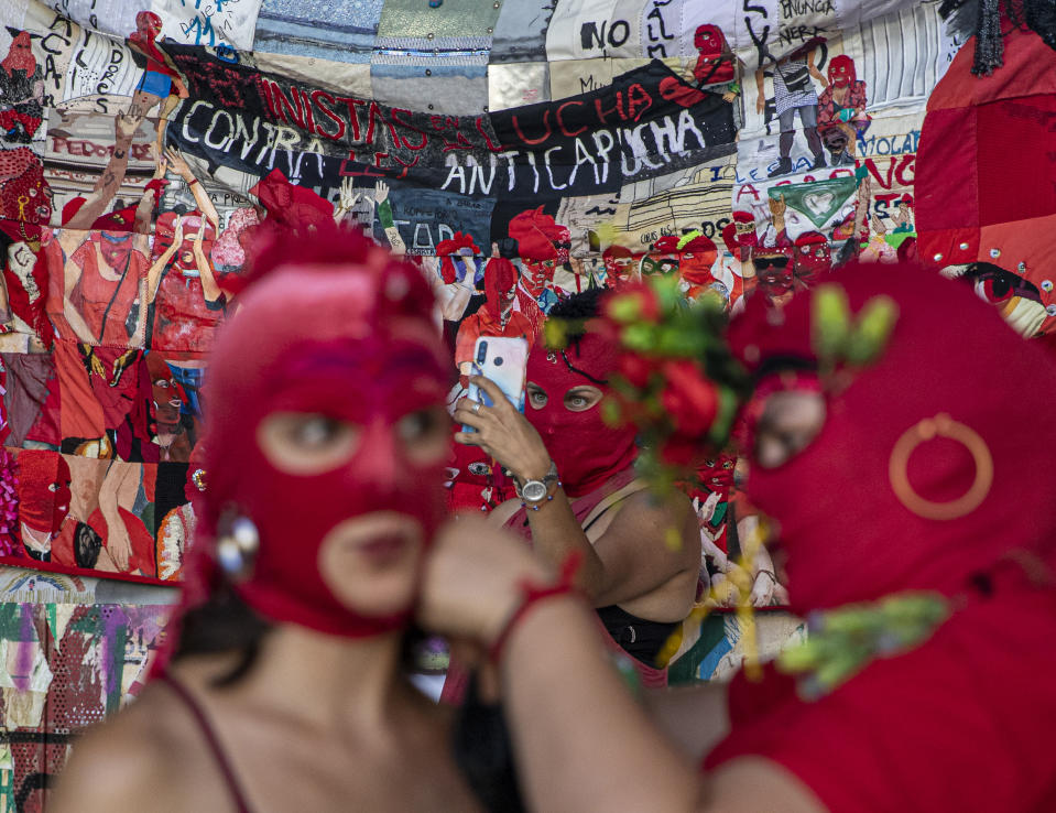 Women put on their masks while another takes a selfie prior to a march for International Women's Day in Santiago, Chile, on Monday, March 8, 2021. (AP Photo/Esteban Félix)