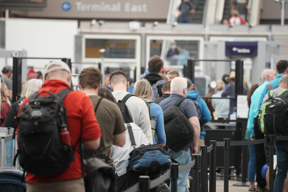 FILE - Travelers queue up at the north security checkpoint in the main terminal of Denver International Airport, Thursday, May 26, 2022, in Denver. Airlines canceled more than 1,000 flights by midmorning Friday, June 17, as they try to recover from storms that raked the center and eastern parts of the country. (AP Photo/David Zalubowski, File)