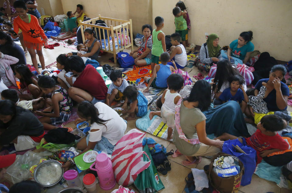 Residents living along the coastal community of Baseco seek temporary shelter at an evacuation center in the onslaught of Typhoon Mangkhut which barreled into northeastern Philippines before dawn Saturday, Sept. 15, 2018 in Manila, Philippines. Philippine officials were assessing damage and checking on possible casualties as Typhoon Mangkhut on Saturday pummeled the northern breadbasket with ferocious wind and rain that set off landslides, damaged an airport terminal and ripped off tin roofs. (AP Photo/Bullit Marquez)