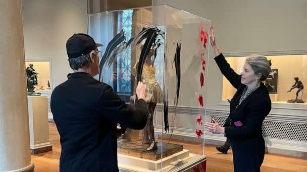 PHOTO: Climate protesters smear paint on the case that houses Edgar Degas's Little Dancer Aged Fourteen at the National Gallery of Art in Washington, April 27, 2023. (The Washington Post via Getty Images)