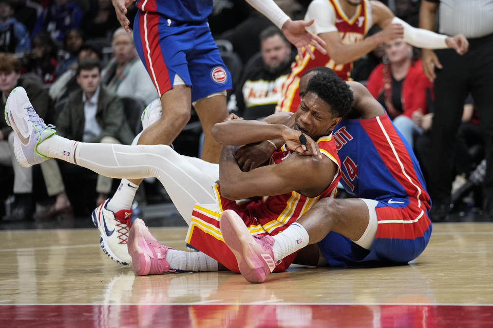 Atlanta Hawks forward De'Andre Hunter (12) battles Detroit Pistons guard Alec Burks (14) fora loose ball during the second half of an NBA basketball game Monday, Dec. 18, 2023, in Atlanta. (AP Photo/John Bazemore)