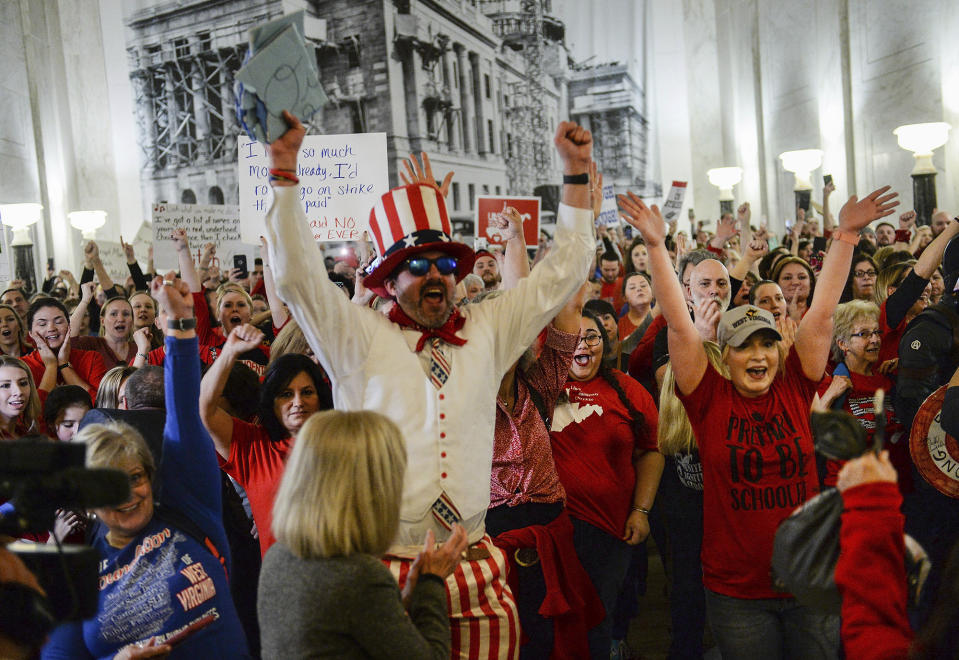 Striking teachers and supporters celebrate outside the West Virginia House of Delegates chamber at the State Capitol in Charleston, W.Va., after the House killed the education omnibus bill Tuesday, Feb. 19, 2019. Tuesday was the first day of the statewide strike for teachers and service personnel. (Chris Dorst/Charleston Gazette-Mail via AP)
