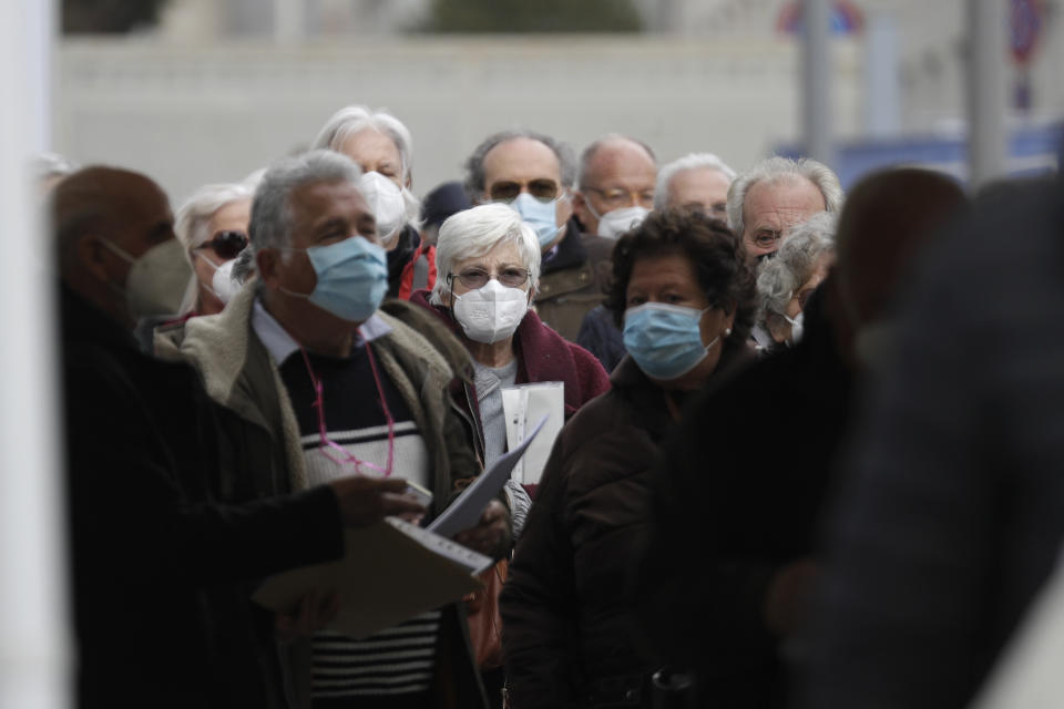 FILE - In this Friday, March 19, 2021 file photo people line up to get their AstraZeneca vaccine shot at La Nuvola (The Cloud) convention center that was temporarily turned into a COVID-19 vaccination hub, in Rome. In some Italian region lawyers, magistrates, professors and other younger professionals got vaccinated against COVID-19 before octogenarians despite government pledges of prioritizing Italy’s oldest citizens. (AP Photo/Gregorio Borgia, file)