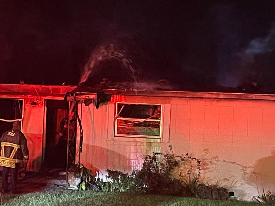 A firefighter pours water to put out any hot spots from a house fire late Thursday night that claimed the life of an elderly woman