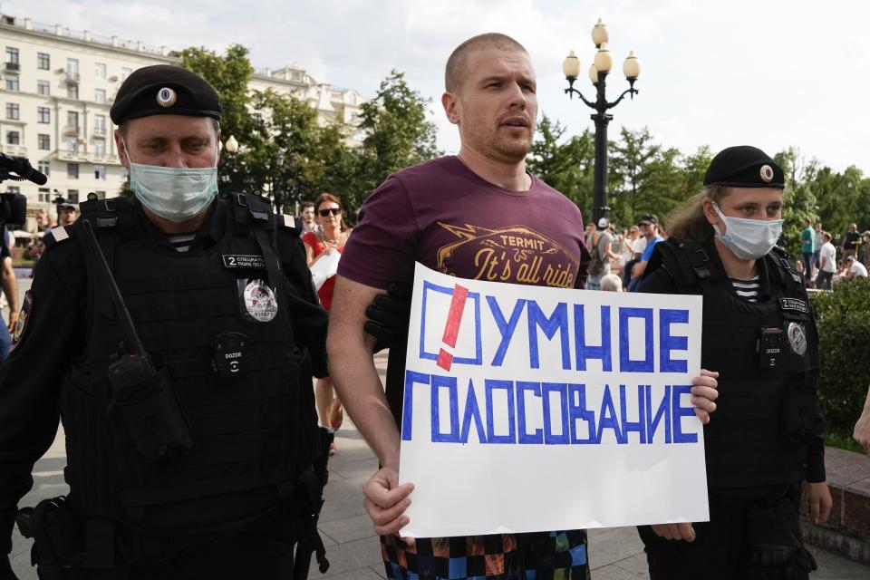 FILE - In this Aug. 14, 2021, file photo, Russian police detain an opposition activist with a poster reading Smart Voting during an anti-vaccination protest in the center of Moscow, Russia. The project, thought up by Navalny, is designed to promote candidates that are most likely to defeat those backed by the Kremlin. It has proven to be effective in some regional elections in the past two years. (AP Photo/Alexander Zemlianichenko, File)