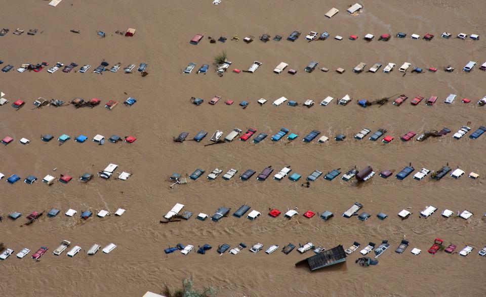 FILE - In this Saturday, Sept. 14, 2013 file photo, a field of parked cars and trucks sits partially submerged near Greeley, Colo., as debris-filled rivers flooded into towns and farms miles from the Rockies. On Wednesday, Jan. 14, 2014, scientists from National Oceanic and Atmospheric Administration say 2013 was the wettest year for the continental U.S. since 2009. The average rainfall totaled 31 inches, 2 inches above the previous century's average. (AP Photo/John Wark)