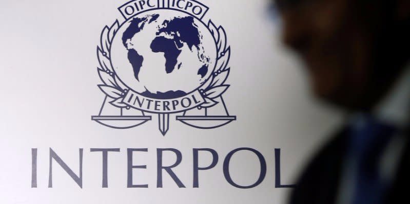 FILE PHOTO -  A man passes an Interpol logo during the handing over ceremony of the new premises for Interpol's Global Complex for Innovation, a research and development facility, in Singapore September 30, 2014. REUTERS/Edgar Su/File Photo - RTSIHYZ