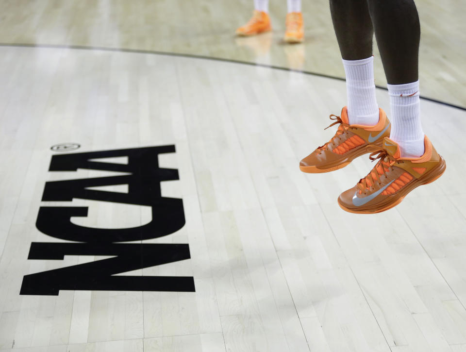 FILE - In this March 21, 2013, file photo, an athlete jumps near the NCAA logo during practice for a second-round game of the NCAA college basketball tournament in Austin, Texas. Defying the NCAA, California's governor signed a first-in-the-nation law Monday, Sept. 30, that will let college athletes hire agents and make money from endorsements — a move that could upend amateur sports in the U.S. and trigger a legal challenge. (AP Photo/Eric Gay, File)