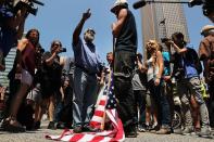 <p>Eine US-amerikanische Flagge liegt zu Füßen eines Anarchisten, der mit einem Polizisten nahe des Kongresses der Republikaner in Downtown, Cleveland, spricht. Der Kongress tagt zu dieser Zeit bereits zwei Tage. (Bild: Spencer Platt/ Getty Images) </p>