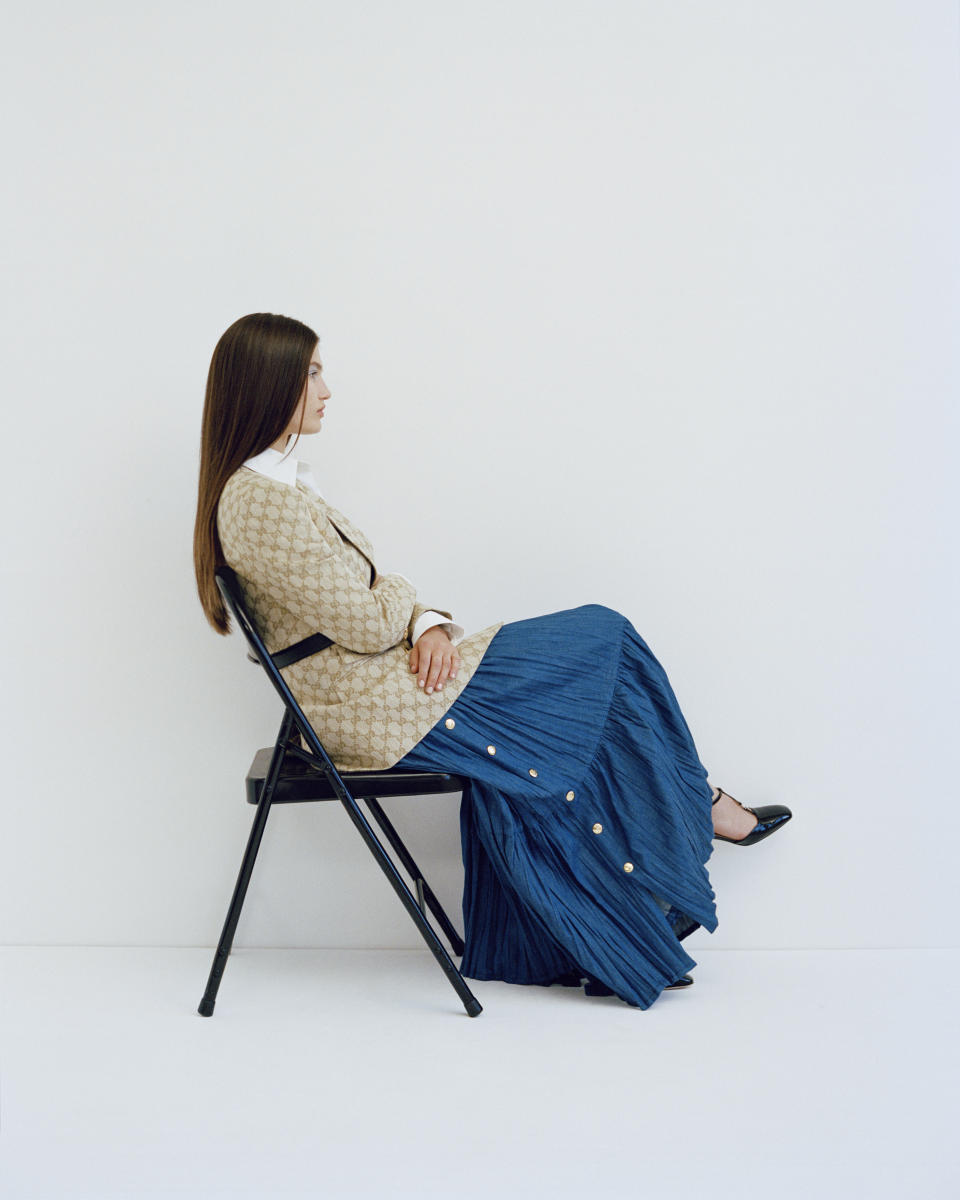 model in chair, blue skirt jacket