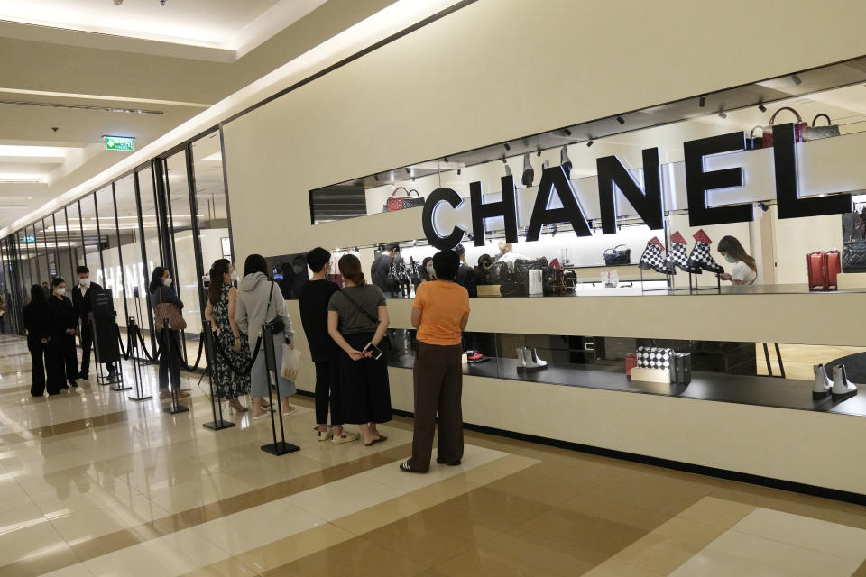 Customers line up outside a shop during the opening at Paragon shopping mall in Bangkok, Thailand, Wednesday, Sept. 1, 2021. Thailand is to ease business lockdown measures in the capital and provinces where restrictions have been implemented since mid-July. Malls, hair salons, foot massage parlors, and parks will be allowed to re-open, as well as restaurants for dine-in services but maintained at 50% capacity. (AP Photo/Sakchai Lalit)