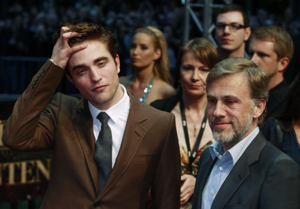 Actors Robert Pattinson (L) and Christoph Waltz pose for pictures as they arrive at the German premiere of their movie "Water for Elephants" in Berlin, April 27, 2011.  REUTERS/Thomas Peter (GERMANY - Tags: ENTERTAINMENT)